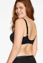 Zijde van vrouw die de minimizer bh met side smoother in de kleur zwart van het merk Naturana draagt