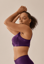 Zijde van vrouw die de minimizer bh met bloemenpatroon in de kleur beetroot van het merk Naturana draagt