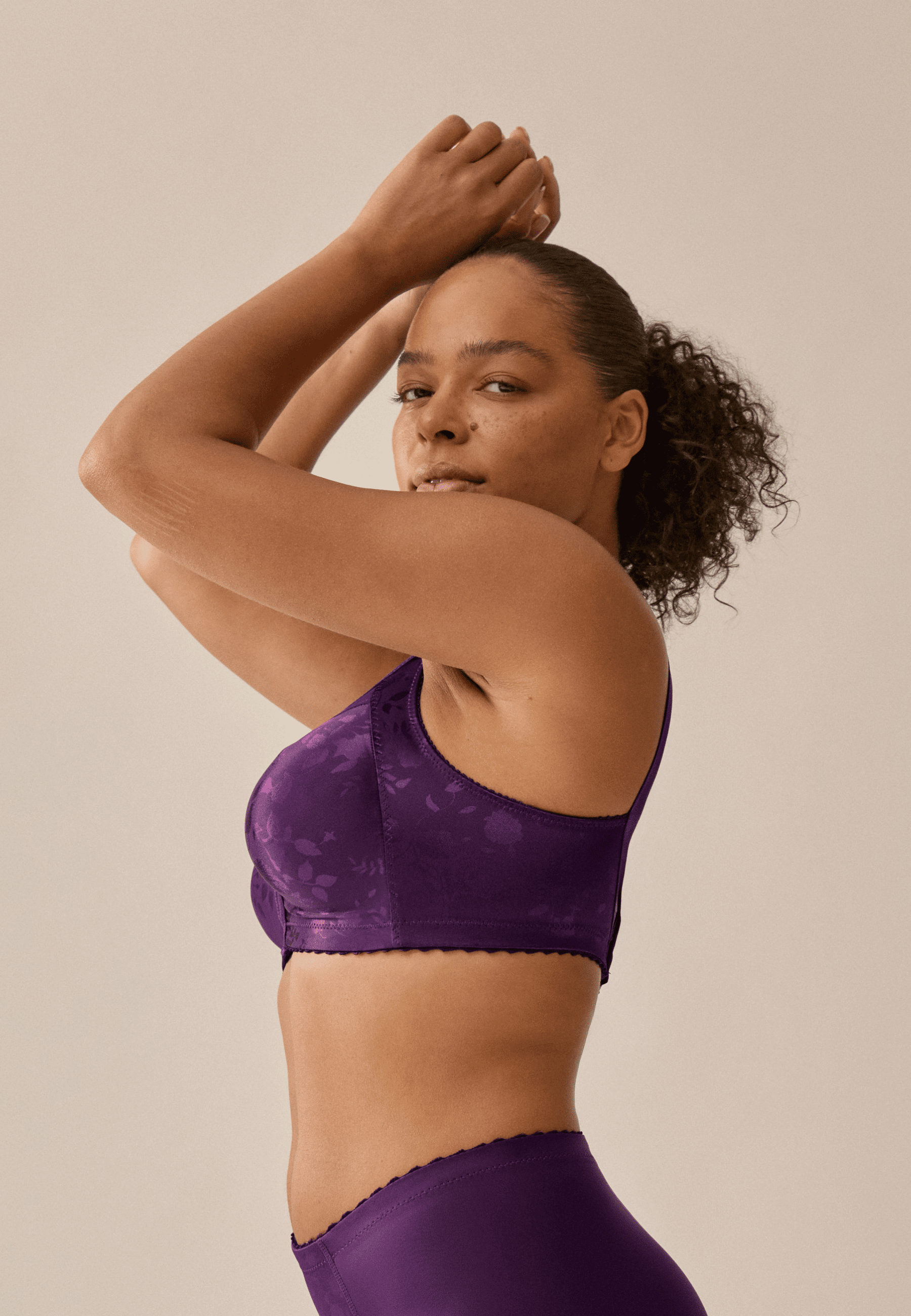 Zijde van vrouw die de minimizer bh met bloemenpatroon in de kleur beetroot van het merk Naturana draagt