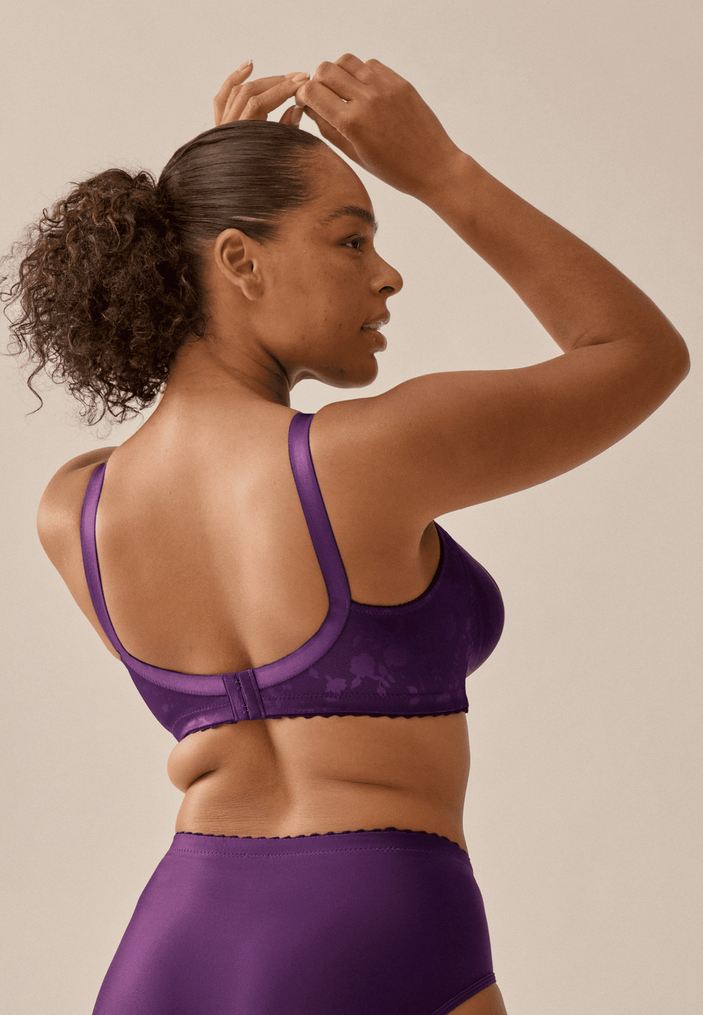 Achterzijde van vrouw die de minimizer bh met bloemenpatroon in de kleur beetroot van het merk Naturana draagt