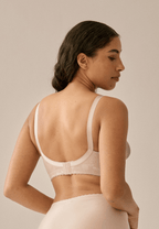 Achterzijde van vrouw die de minimizer bh met bloemenpatroon in de kleur beige van het merk Naturana draagt