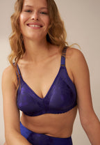 Voorzijde van vrouw die de minimizer bh met bloemenpatroon in de kleur galaxy violet van het merk Naturana draagt