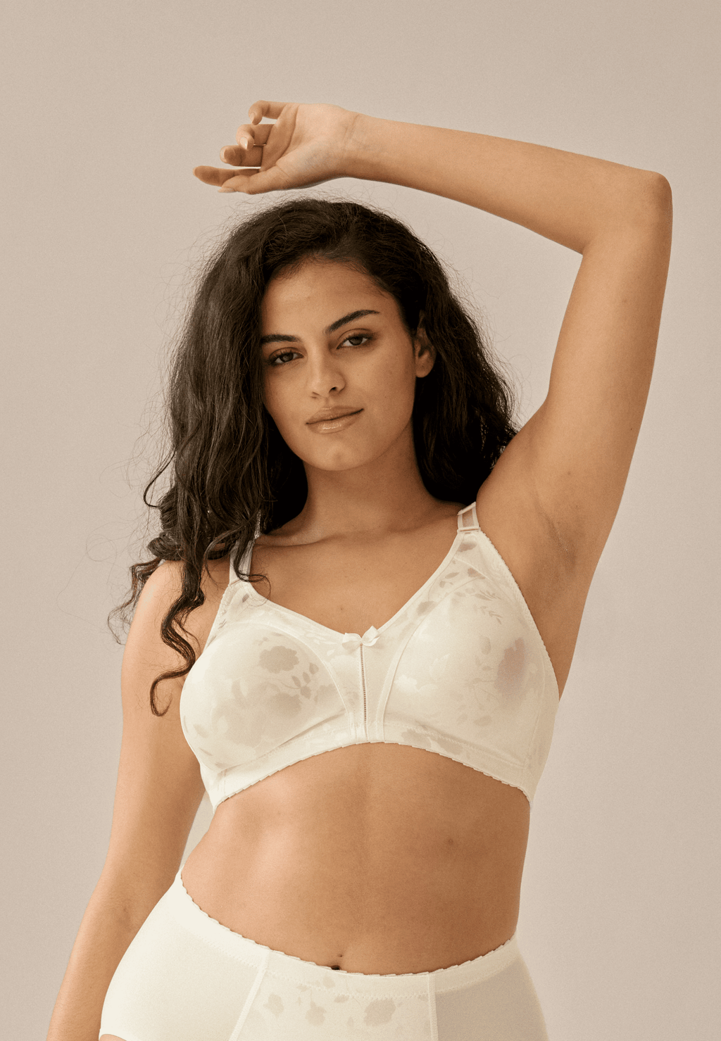 Voorzijde van vrouw die de minimizer bh met bloemenpatroon in de kleur ivoor van het merk Naturana draagt