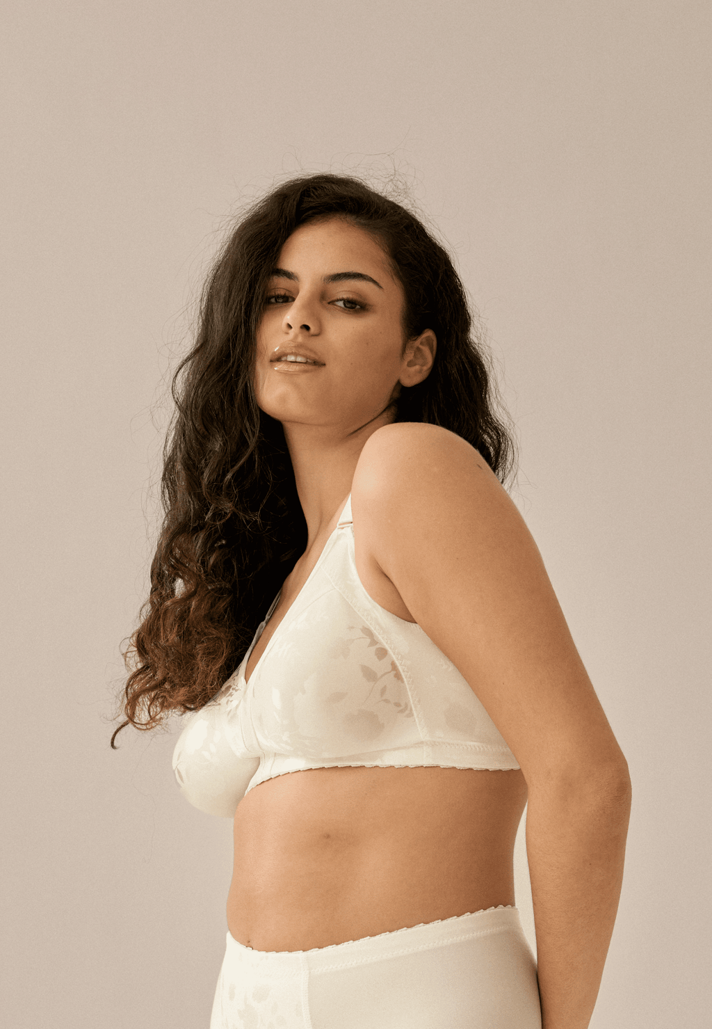 Zijde van vrouw die de minimizer bh met bloemenpatroon in de kleur ivoor van het merk Naturana draagt