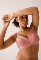Voorzijde van vrouw die de minimizer bh met bloemenpatroon in de kleur pink rose van het merk Naturana draagt