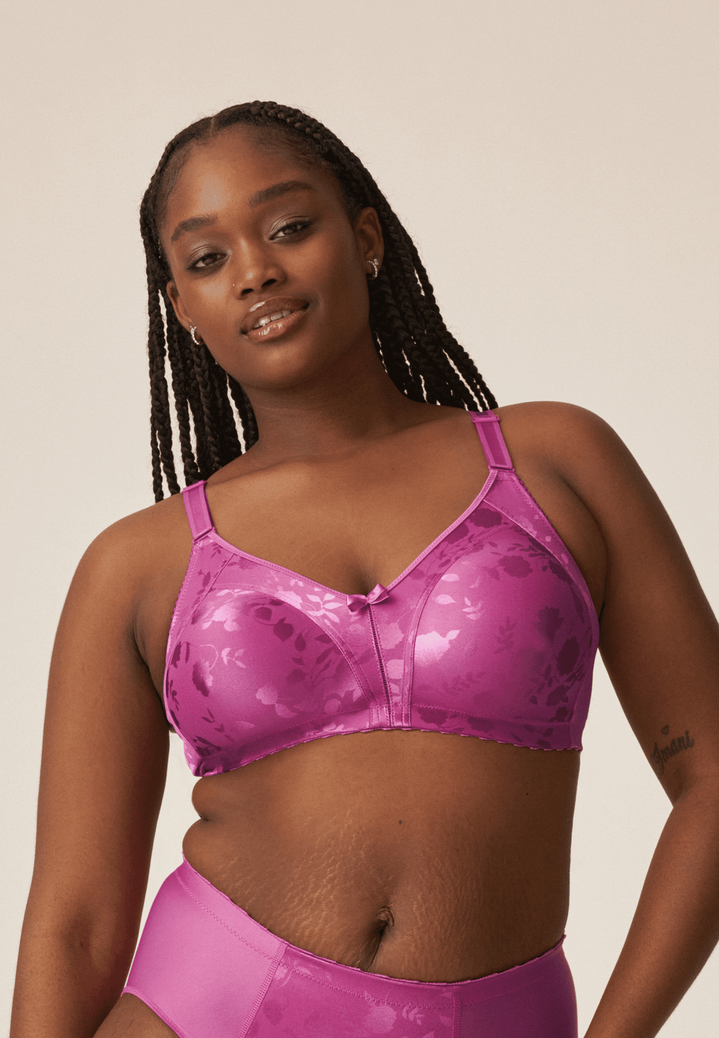 Voorzijde van vrouw die de minimizer bh met bloemenpatroon in de kleur purple orchid van het merk Naturana draagt