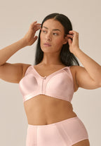 Voorzijde van vrouw die de minimizer bh met glanzend effect in de kleur blush van het merk Naturana draagt