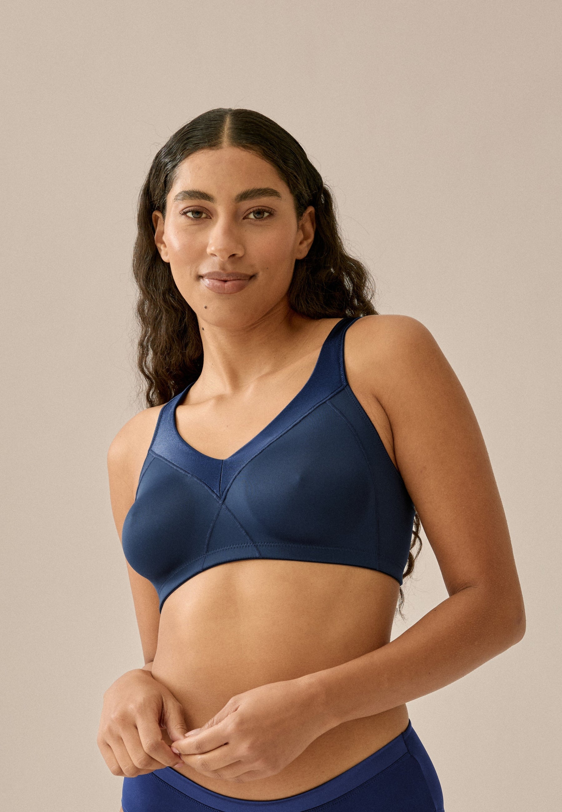 Voorzijde van vrouw die de minimizer bh met glansband in de kleur navy van het merk Naturana draagt
