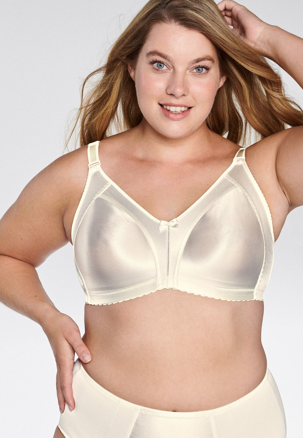 Voorzijde van vrouw die de minimizer bh met glanzend effect in de kleur ivoor van het merk Naturana draagt