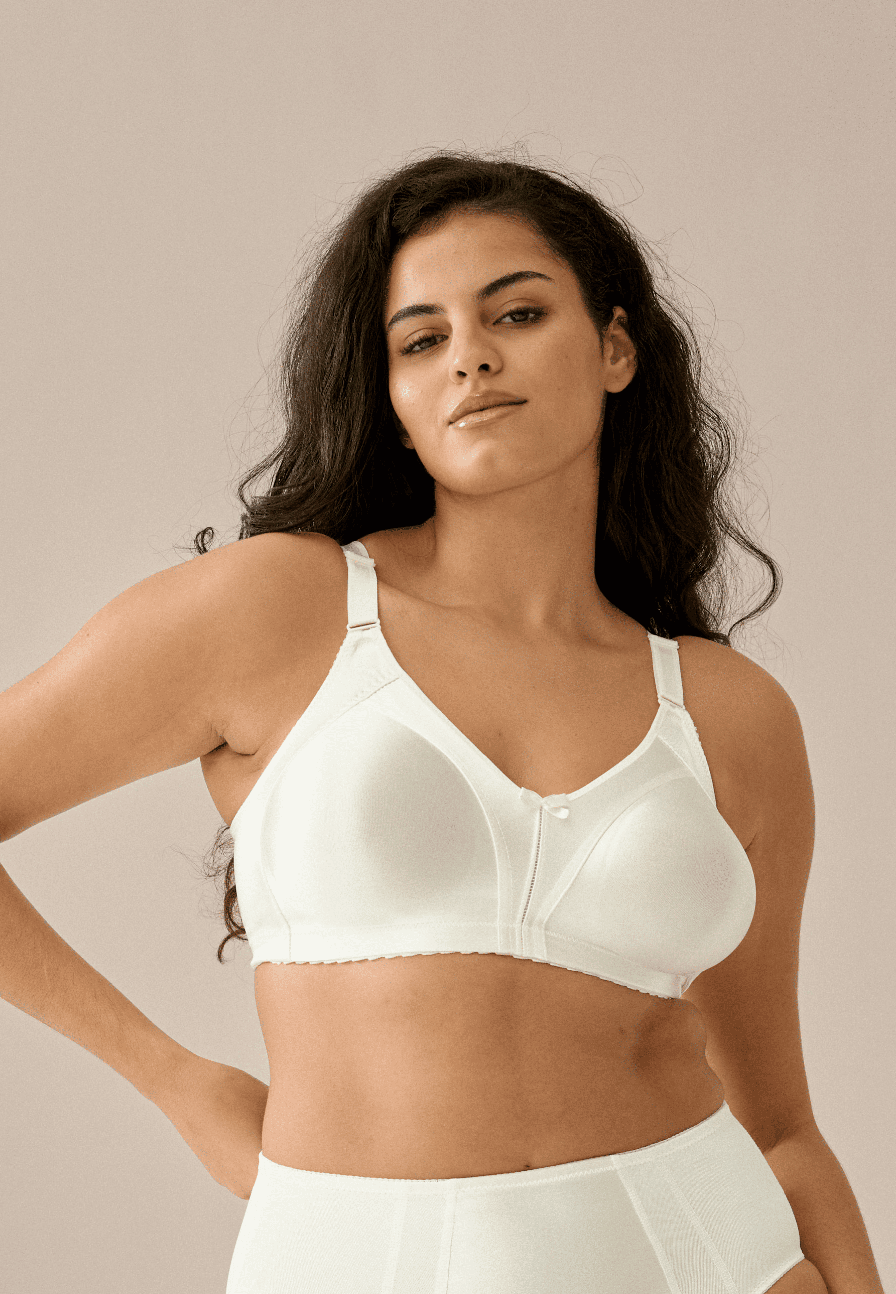 Voorzijde van vrouw die de minimizer bh in de kleur ivoor van het merk Naturana draagt