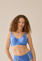 Voorzijde van vrouw die de minimizer bh met mesh detail in de kleur marina blue van het merk Naturana draagt