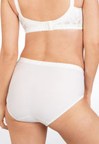 Achterzijde van vrouw die de minimizer bh en minimizer slip met bloemenpatroon in de kleur ivoor van het merk Naturana draagt