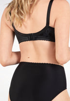 Achterzijde van vrouw die de minimizer bh en minimizer slip met bloemenpatroon in de kleur zwart van het merk Naturana draagt