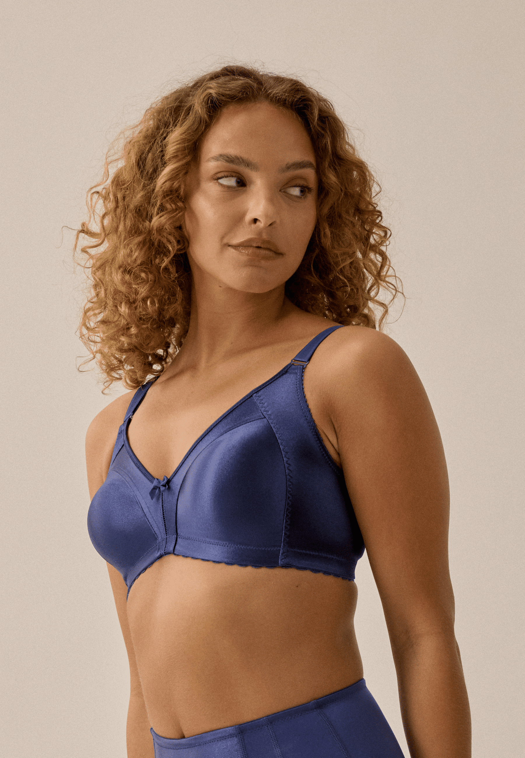 Zijde van vrouw die de minimizer bh in de kleur pacific blue van het merk Naturana draagt