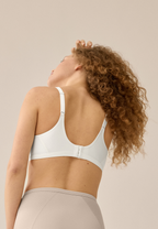 Achterzijde van vrouw die de minimizer bh met patroon in de kleur ecru van het merk Naturana draagt