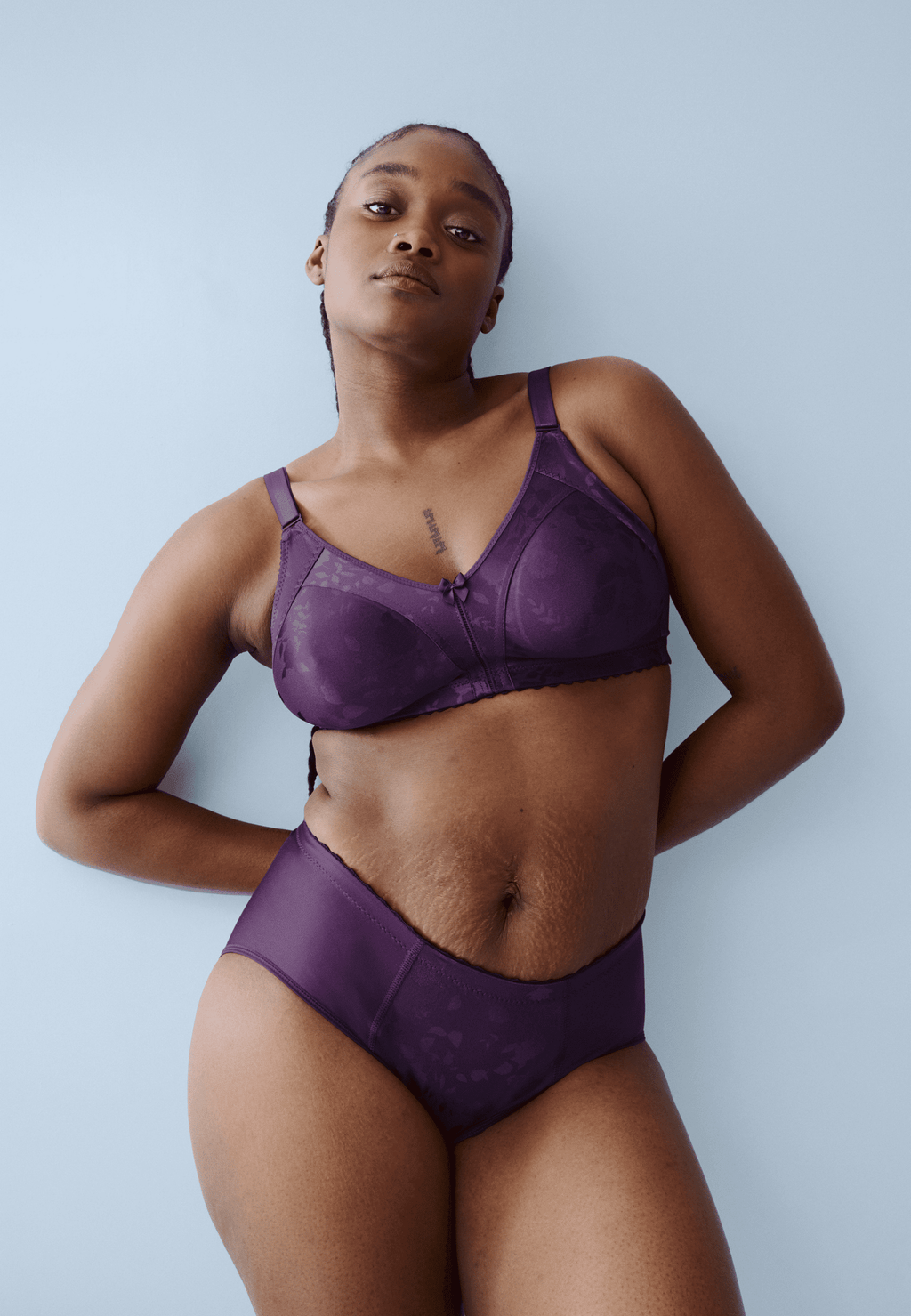 Voorzijde van vrouw die de minimizer bh met bloemenpatroon en de minimizer slip met bloemenpatroon in de kleur beetroot van het merk Naturana draagt