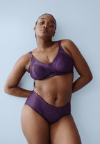 Voorzijde van vrouw die de minimizer bh met bloemenpatroon en de minimizer slip met bloemenpatroon in de kleur beetroot van het merk Naturana draagt