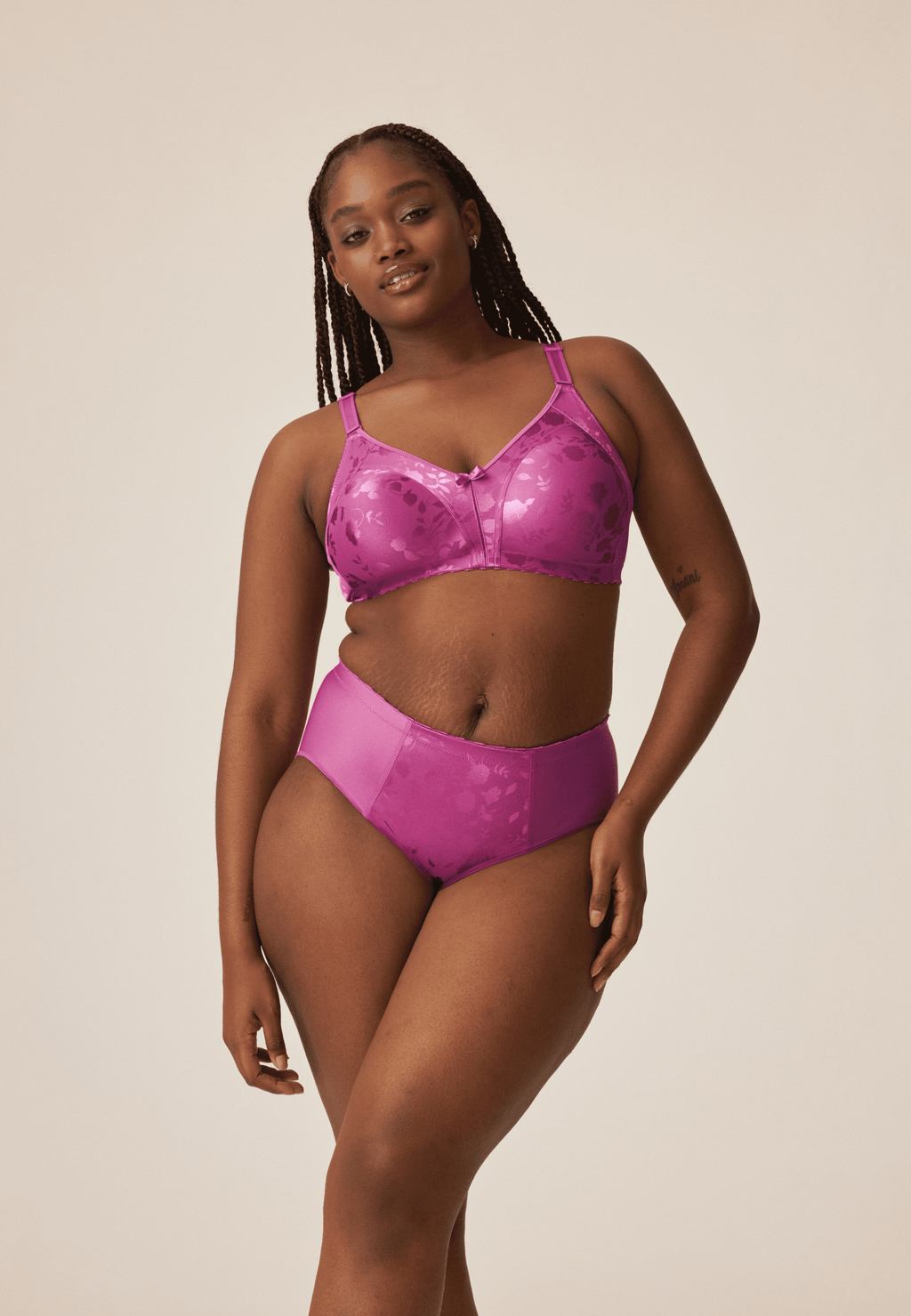 Voorzijde van vrouw die de minimizer bh met bloemenpatroon en de minimizer slip met bloemenpatroon in de kleur purple orchid van het merk Naturana draagt