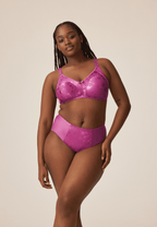Voorzijde van vrouw die de minimizer bh met bloemenpatroon en de minimizer slip met bloemenpatroon in de kleur purple orchid van het merk Naturana draagt