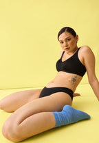 Voorzijde van vrouw die de minimizer bh en slip in de kleur zwart van het merk Naturana draagt