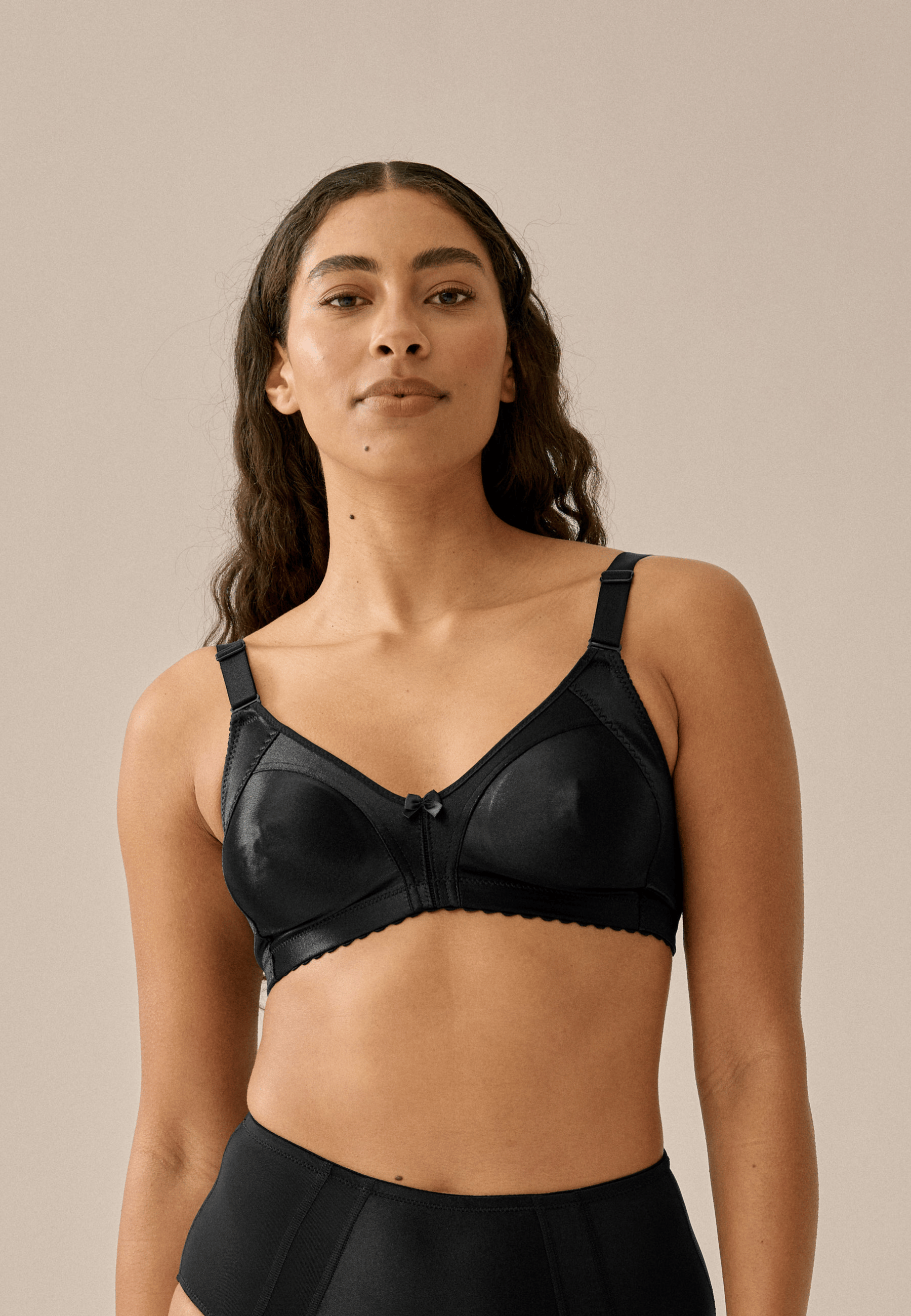 Voorzijde van vrouw die de minimizer bh in de kleur zwart van het merk Naturana draagt
