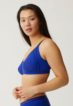 Zijde van vrouw die de minimizer bh in de kleur indigo van het merk Naturana draagt