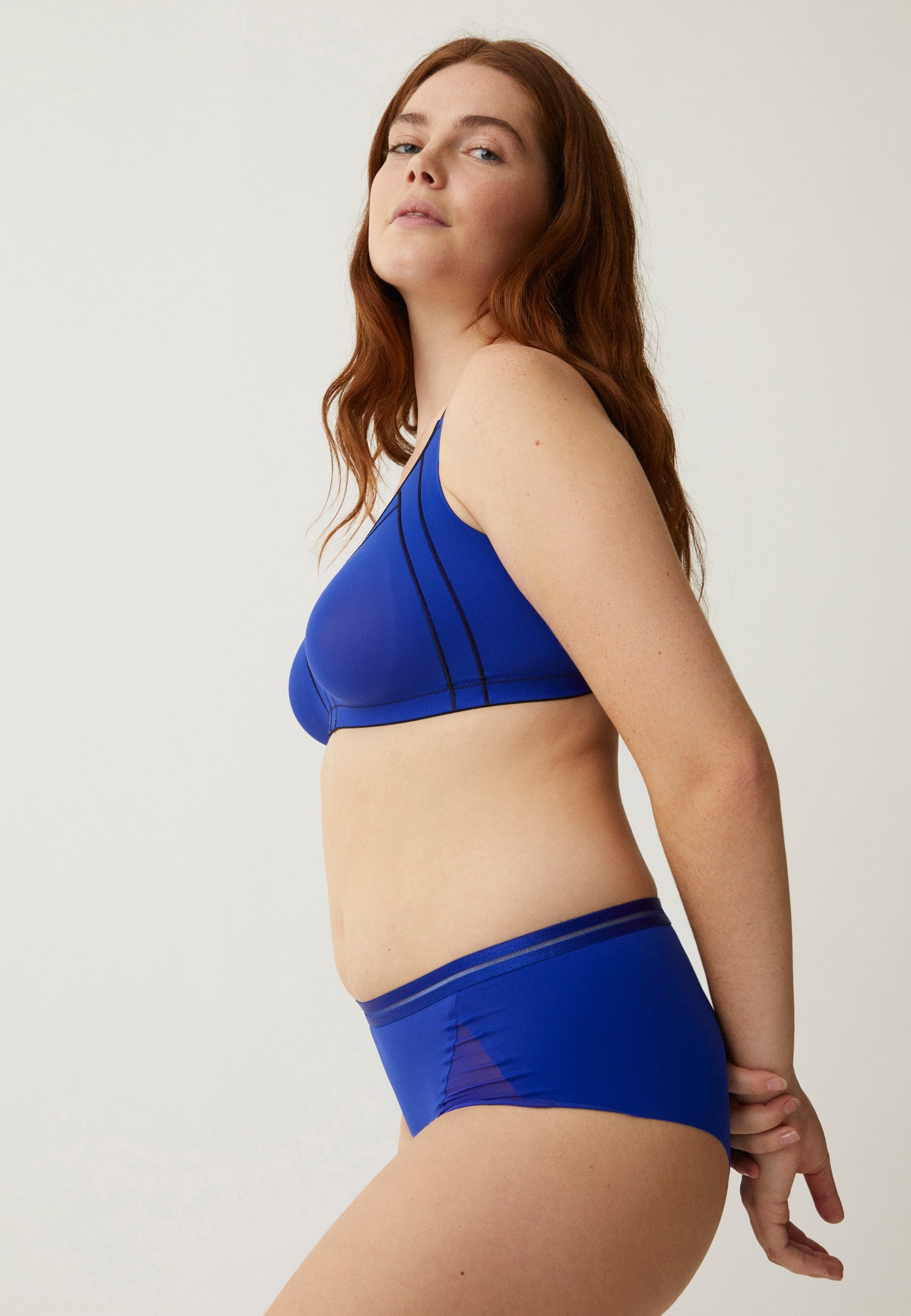 Zijde van vrouw die de minimizer bh in de kleur indigo van het merk Naturana draagt