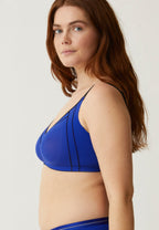 Zijde van vrouw die de minimizer bh in de kleur indigo van het merk Naturana draagt