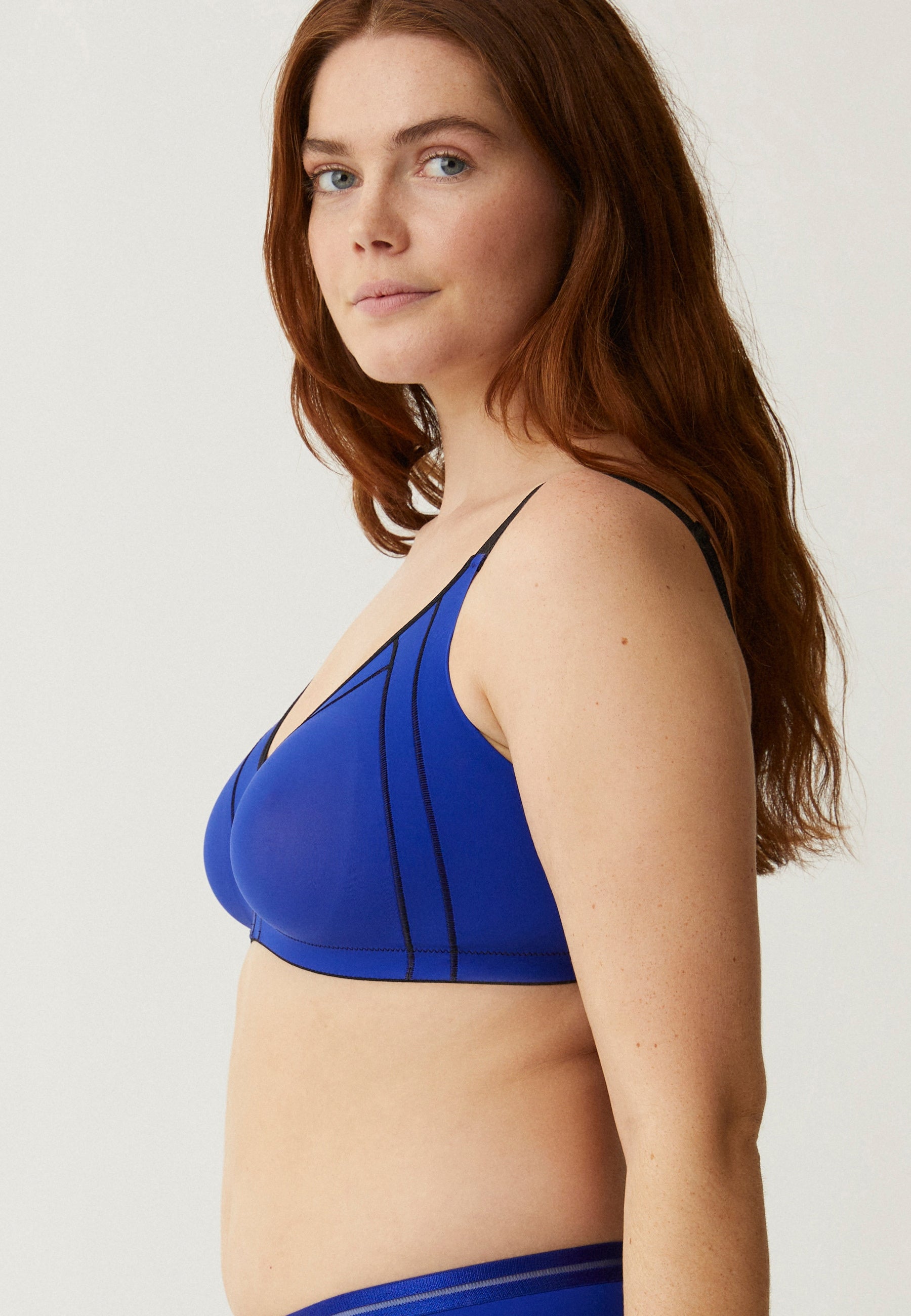 Zijde van vrouw die de minimizer bh in de kleur indigo van het merk Naturana draagt