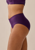 Zijde van vrouw die de minimizer slip met bloemenpatroon in de kleur beetroot  van het merk Naturana draagt