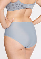 Achterzijde van vrouw die de minimizer slip met bloemenpatroon in de kleur raindrops van het merk Naturana draagt