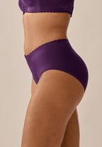 Zijde van vrouw die de minimizer slip met bloemenpatroon in de kleur beetroot van het merk Naturana draagt