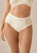 Voorzijde van vrouw die de minimizer slip met bloemenpatroon in de kleur ivoor van het merk Naturana draagt