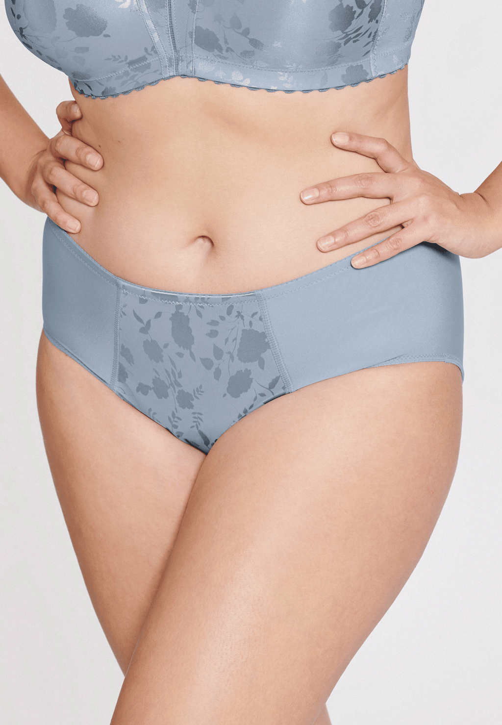 Voorzijde van vrouw die de minimizer slip met bloemenpatroon in de kleur raindrops van het merk Naturana draagt