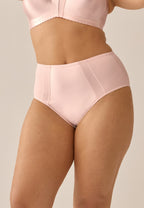 Voorzijde van vrouw die de minimizer slip met glanzend effect in de kleur blush van het merk Naturana draagt