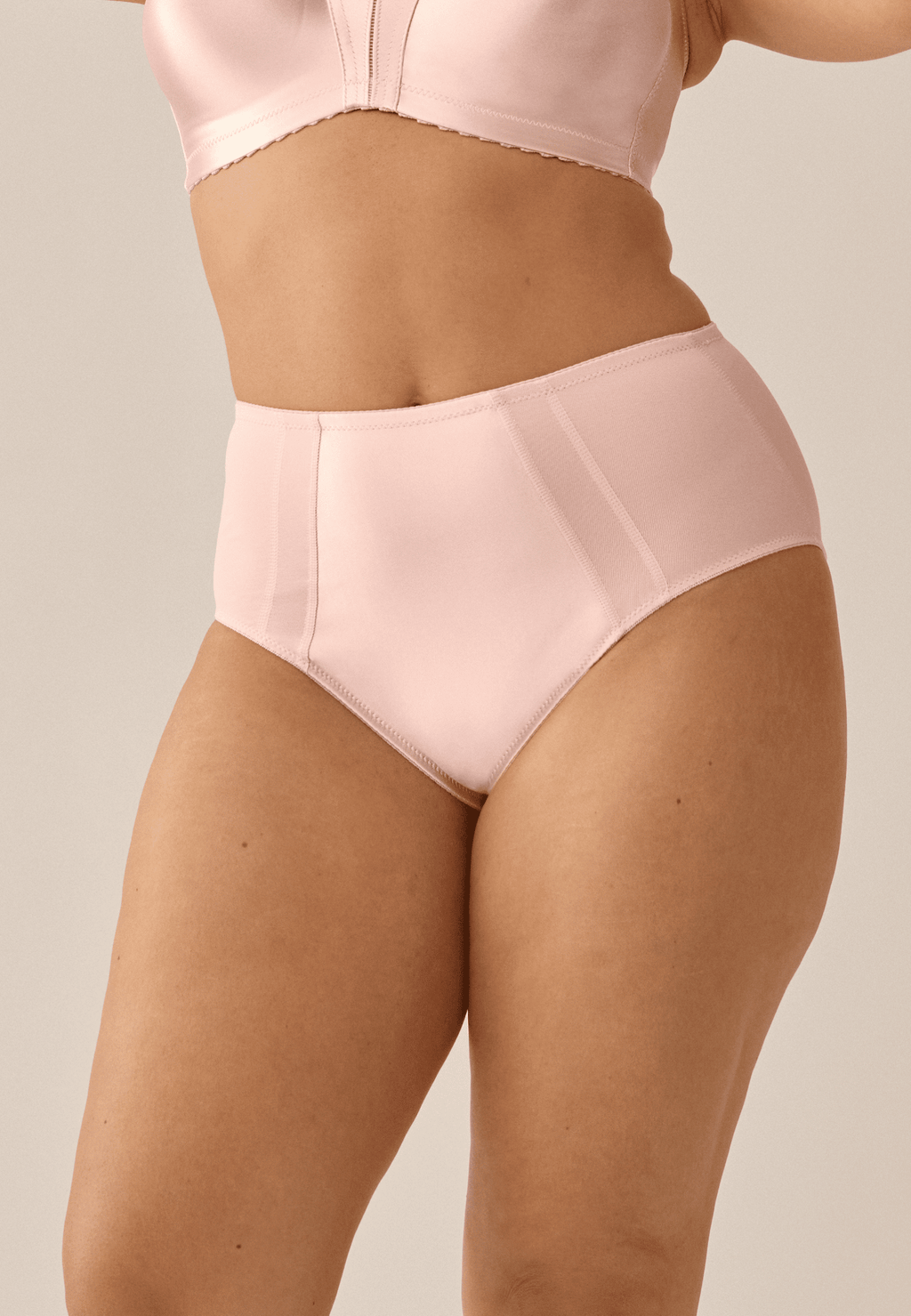 Voorzijde van vrouw die de minimizer slip in de kleur blush van het merk Naturana draagt