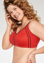 Zijde van vrouw die de minimizer bh met side smoother in de kleur rood van het merk Naturana draagt