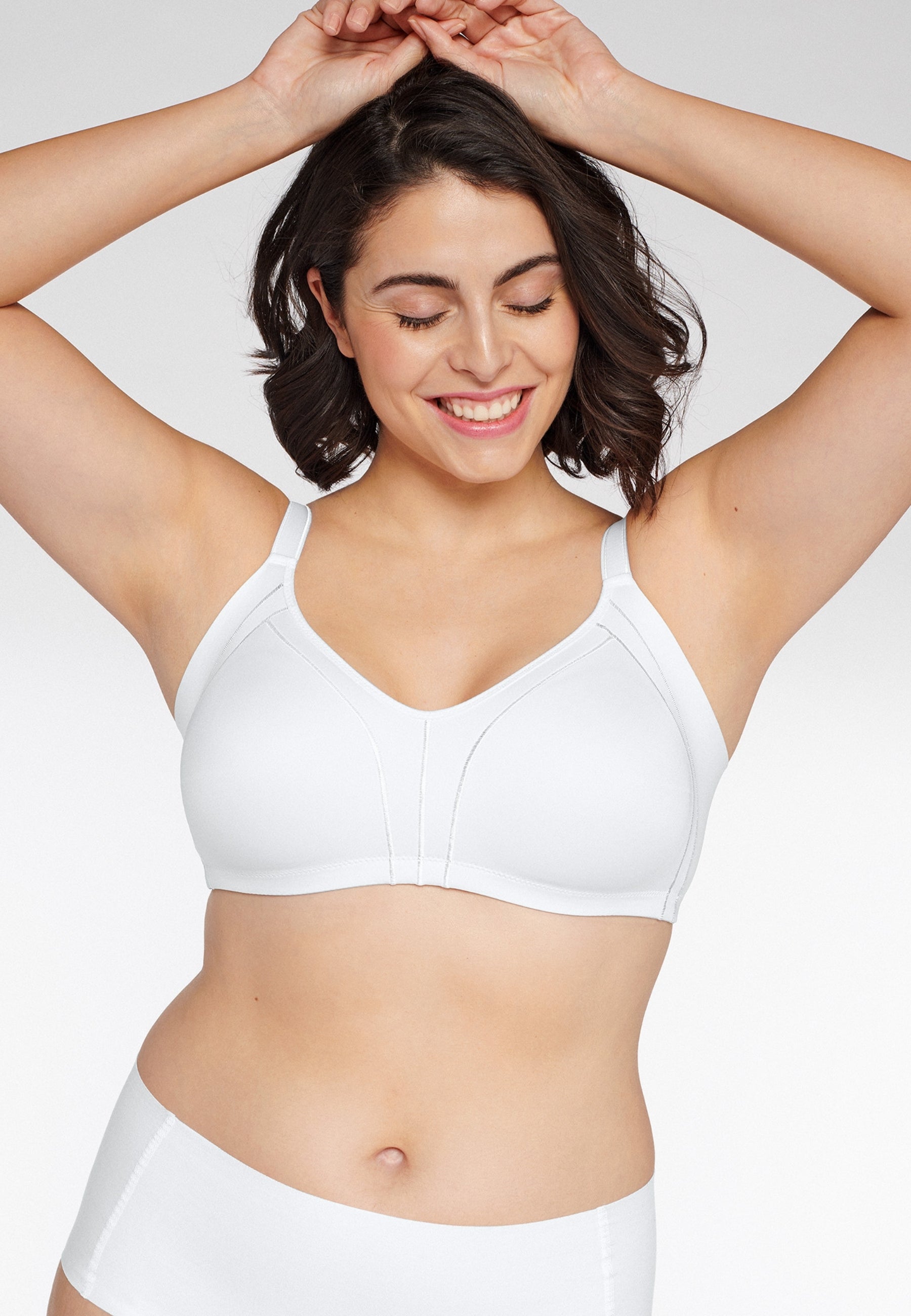 Voorzijde van vrouw die de minimizer bh met side smoother in de kleur wit van het merk Naturana draagt