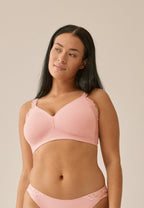 Voorzijde van vrouw die de side smoother bh met kant in de kleur pink rose van het merk Naturana draagt