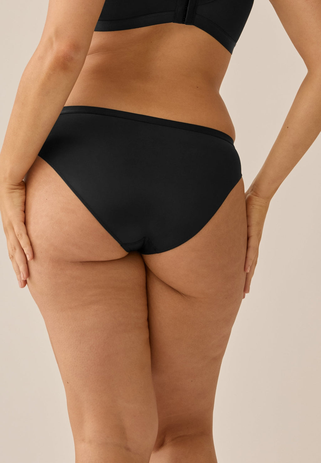 Achterzijde van vrouw die de slip in de kleur zwart van het merk Naturana draagt