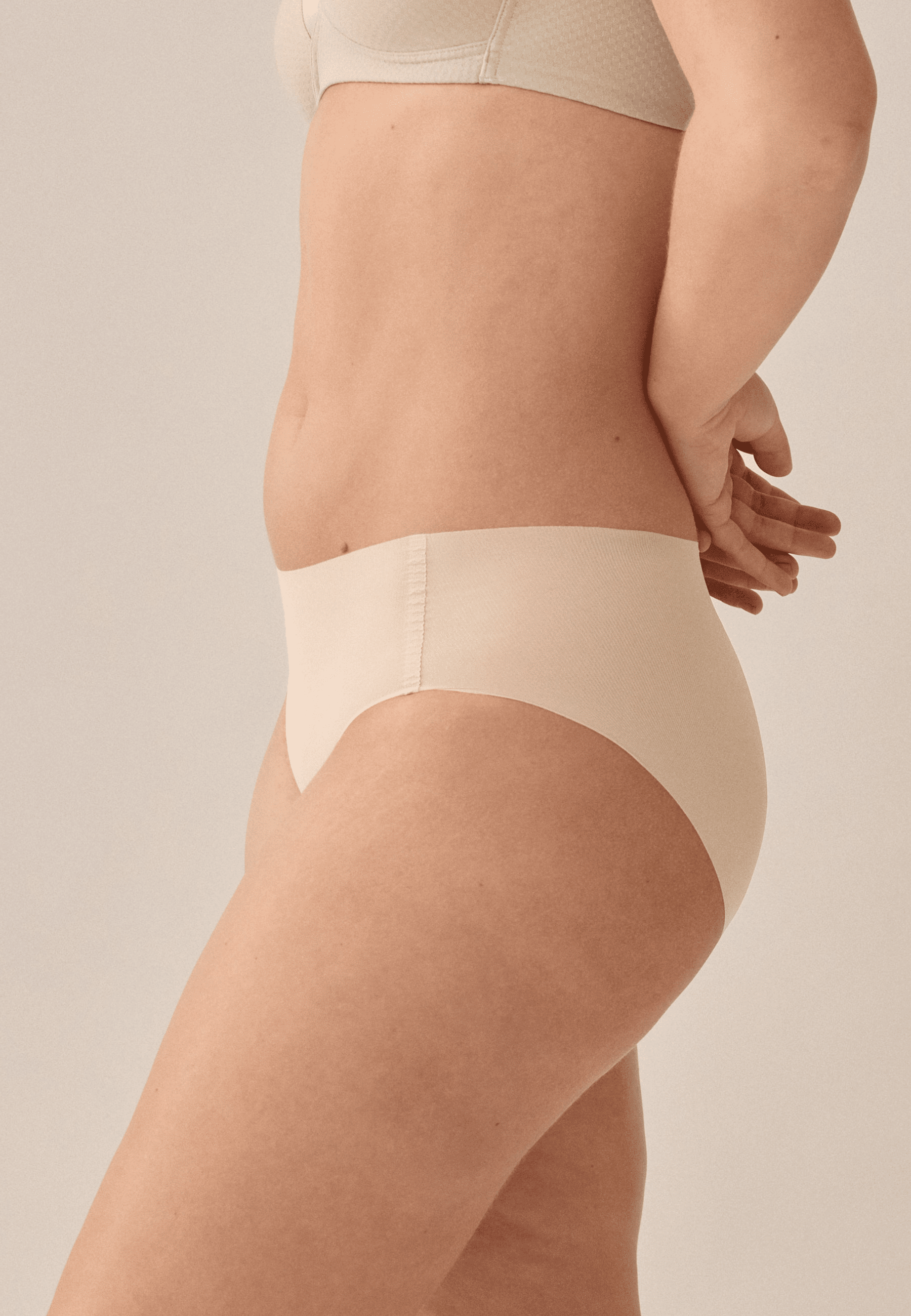 Zijde van vrouw die de one size slip in de kleur beige van het merk Naturana draagt