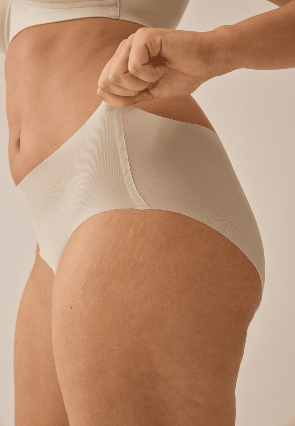 Zijde van vrouw die de one size slip in de kleur beige van het merk Naturana draagt