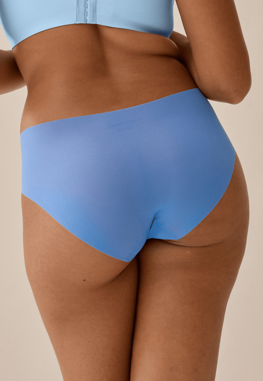 Achterzijde van vrouw die de one size slip in de kleur marina blue van het merk Naturana draagt