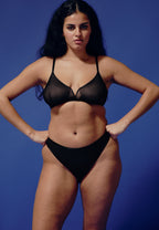 Voorzijde van vrouw die de sheer mesh  bh en sheer mesh string in de kleur zwart van het merk Naturana draagt