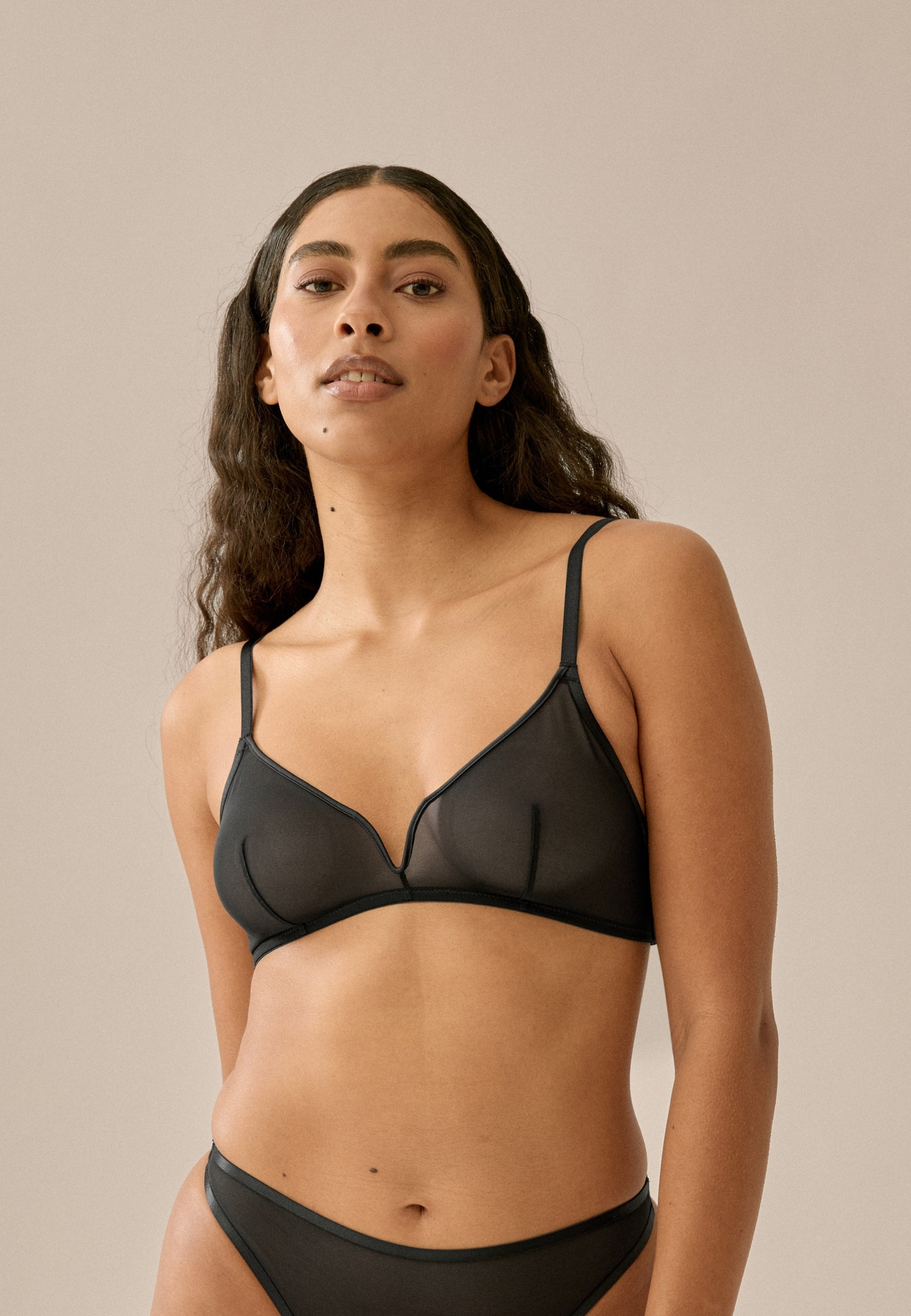 Voorzijde van vrouw die de sheer mesh bh in de kleur zwart van het merk Naturana draagt