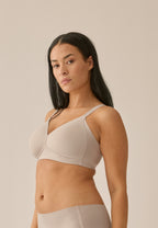 Zijde van vrouw die de side smoother bh in de kleur beige van het merk Naturana draagt