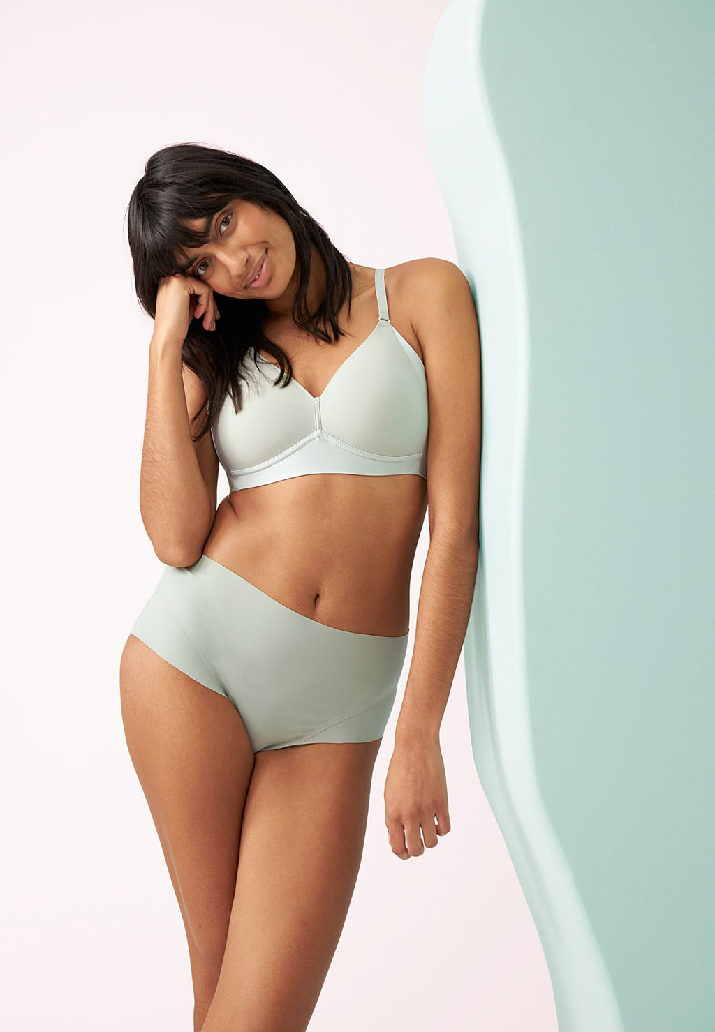 Voorzijde van vrouw die de side smoother bh en de high waist slip in de kleur pale greenshield van het merk Naturana draagt