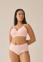 Voorzijde van vrouw die de side smoother bh en high waist slip in de kleur blush van het merk Naturana draagt