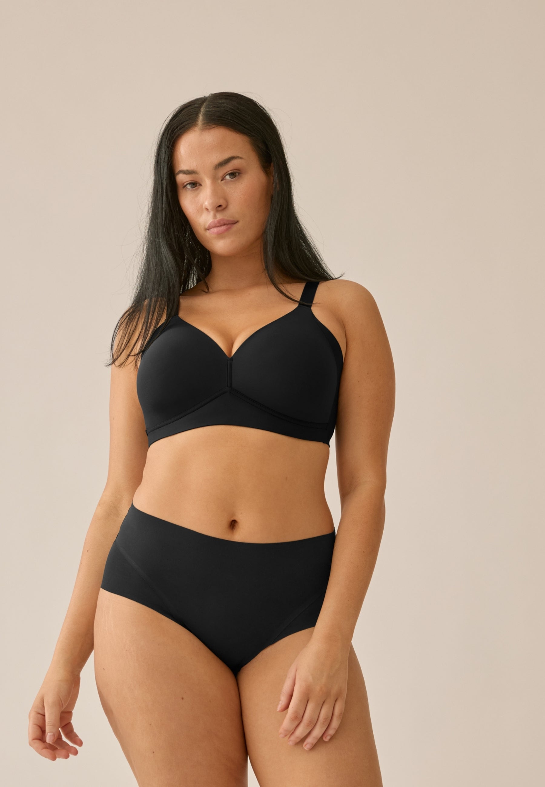 Voorzijde van vrouw die de side smoother bh en high waist slip in de kleur zwart van het merk Naturana draagt