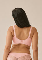 Achterzijde van vrouw die de side smoother bh met kant in de kleur pink rose van het merk Naturana draagt